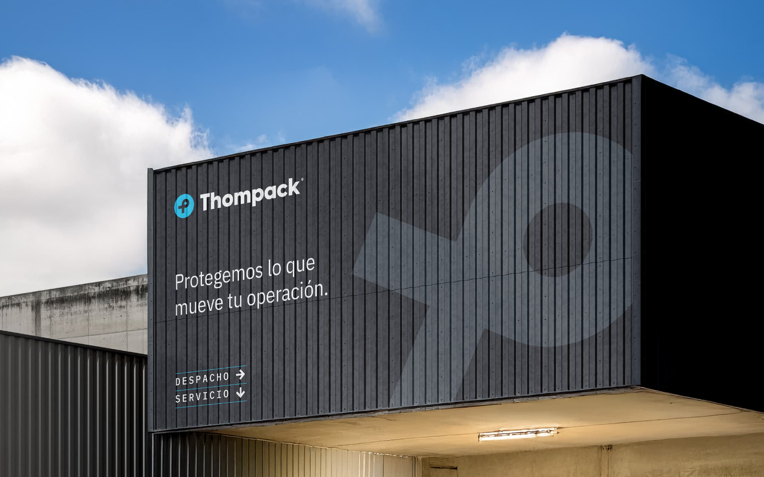 Thompack warehouse signage applied to an industrial facade for a B2B packaging brand.